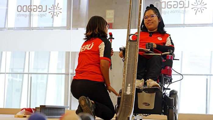 Para atleta de boccia en silla de ruedas junto a su asistente de rampa